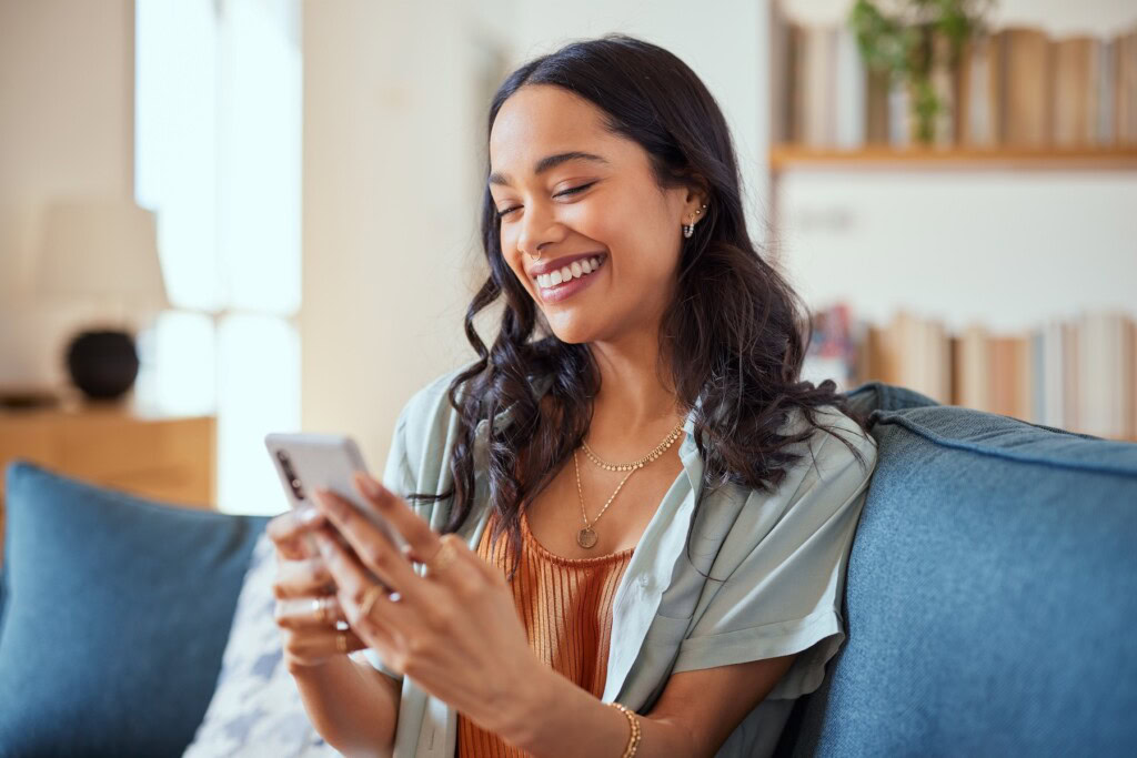 Woman smiling while checking her mobile phone