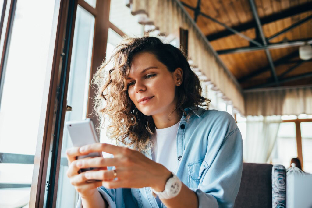 Young woman looking at mobile phone in a cafe