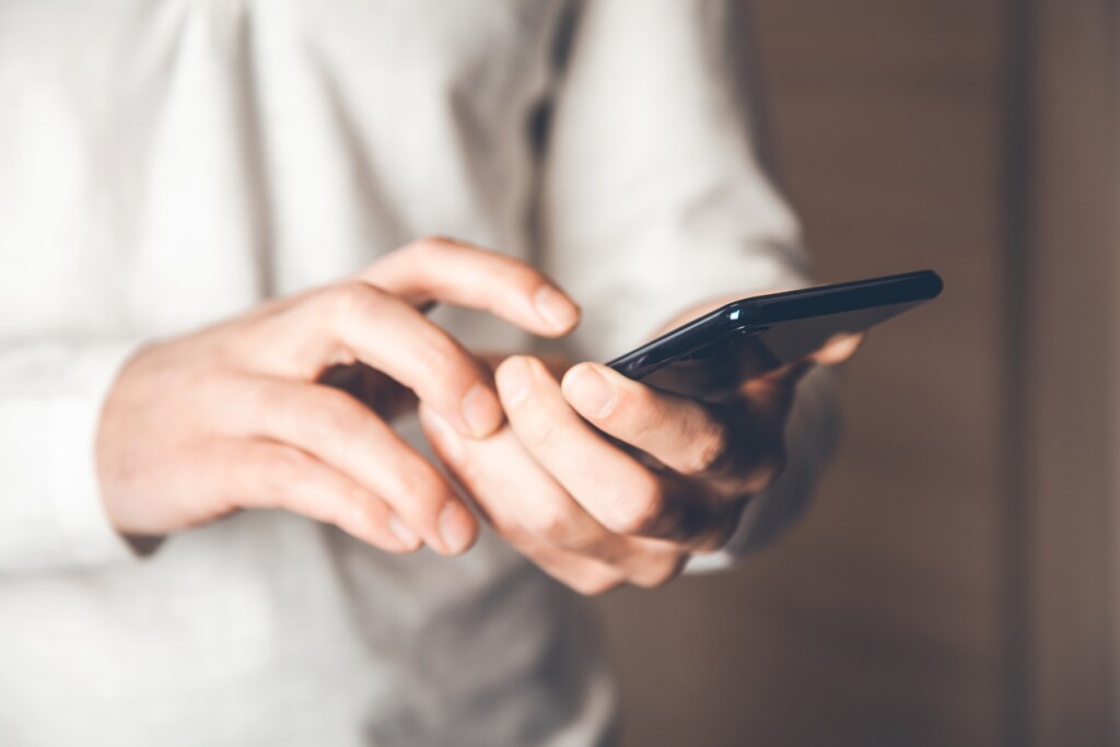 Closse up of young man's hands holding smart phone